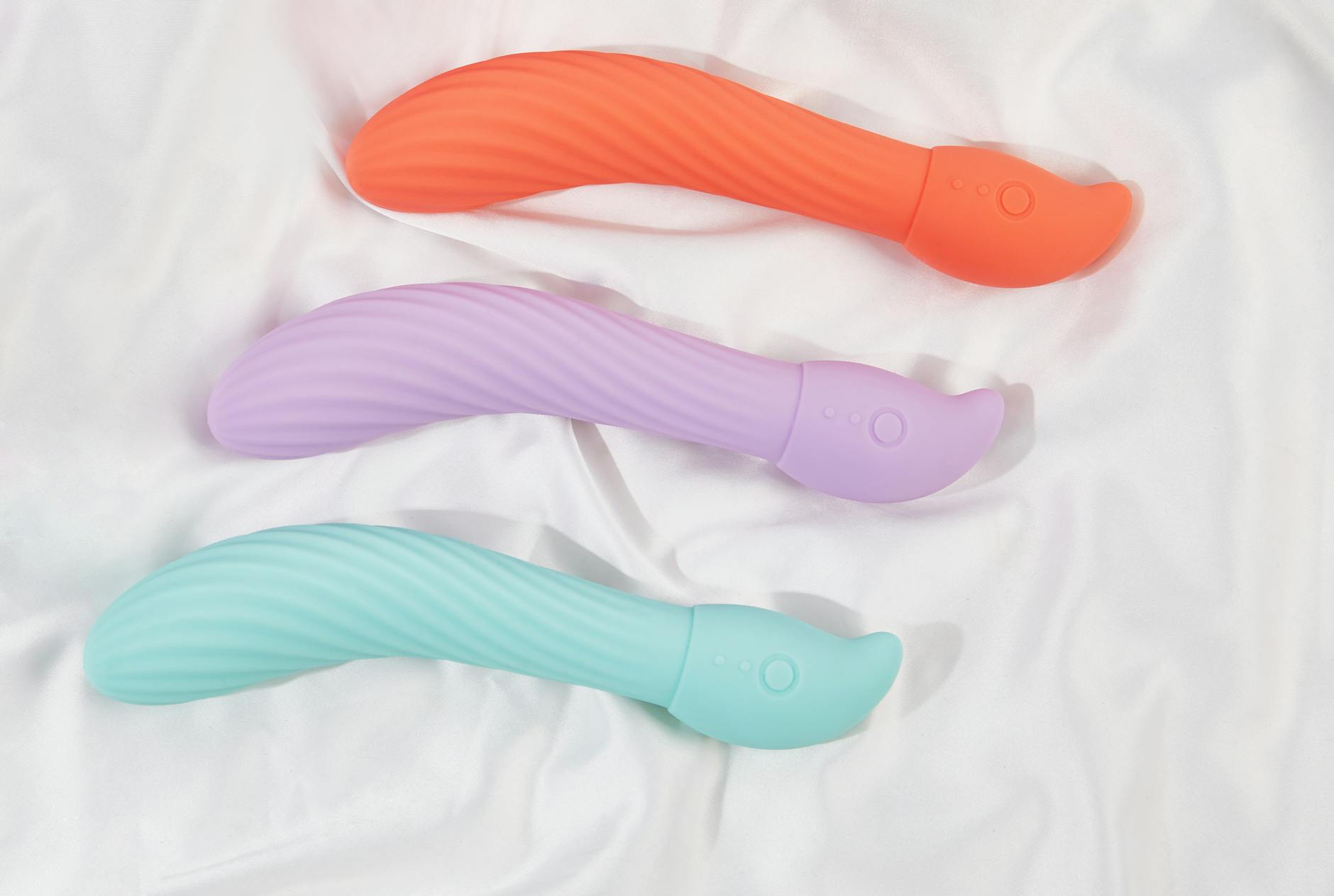 Pink vibrator on purple background with heart confetti and candles for intimate moments