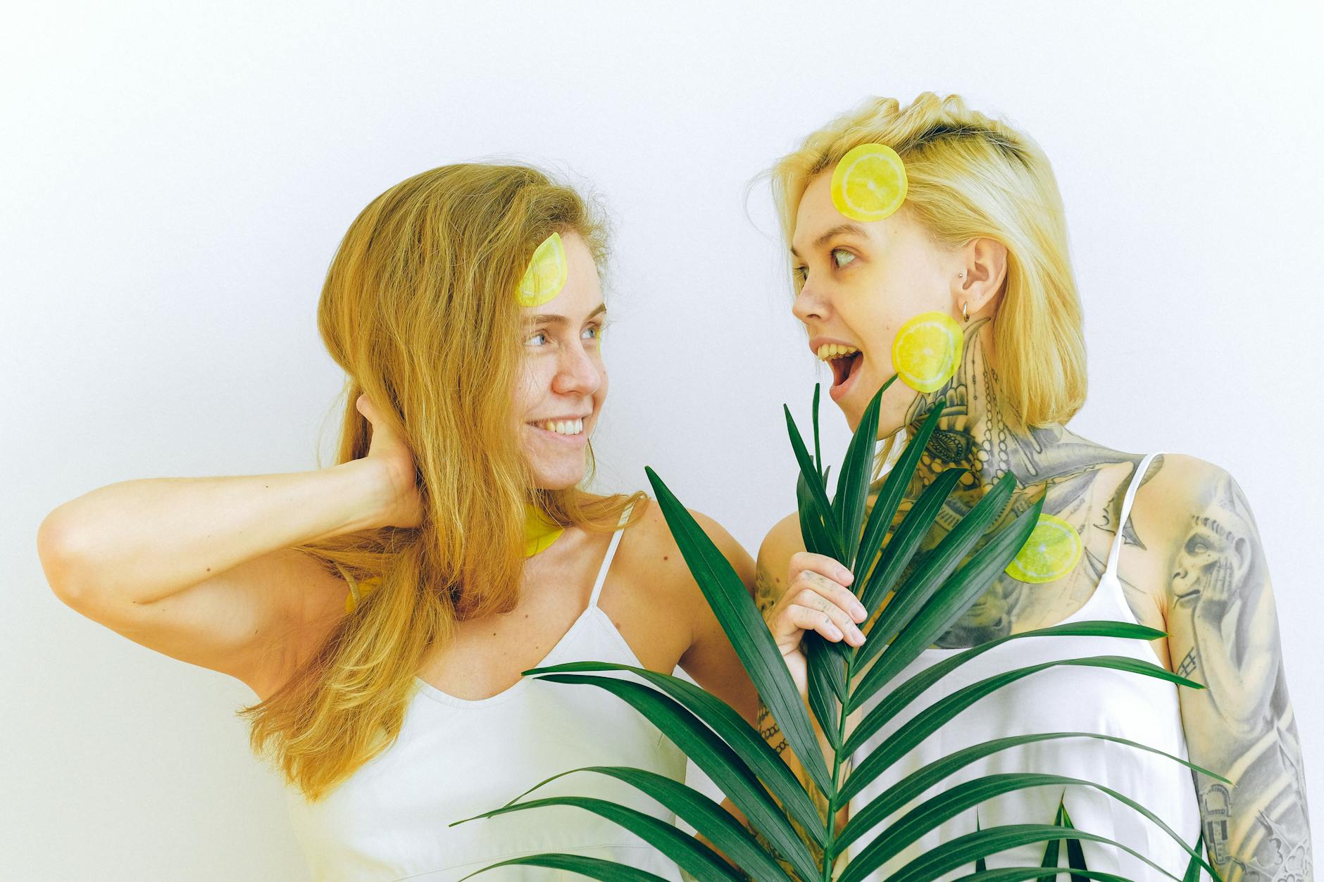 Two women laughing together with lemon slices, expressing joy and comfort in conversation