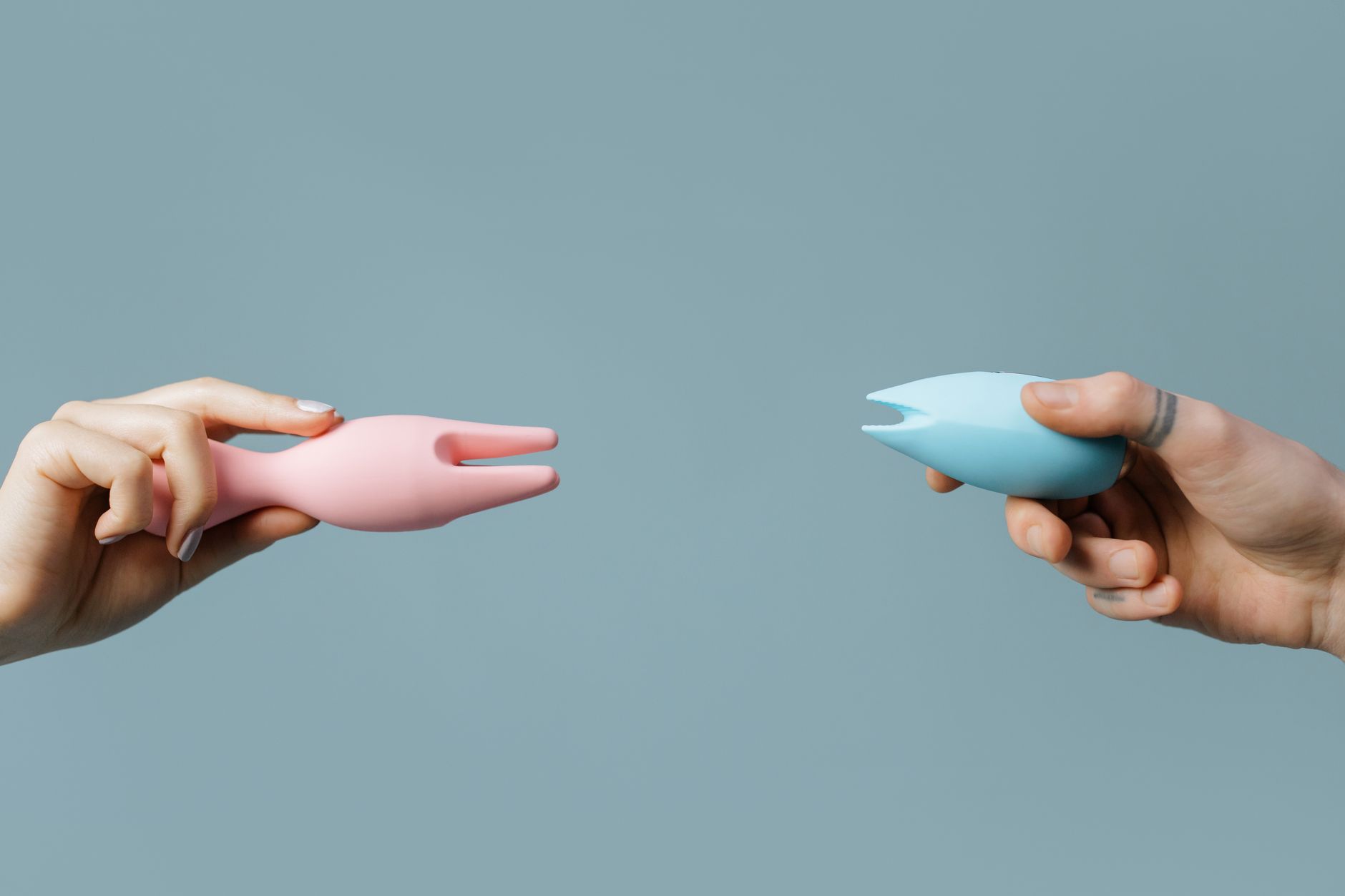 A hand holding a lemon on soft pink background, symbolizing renewal and fresh pleasure