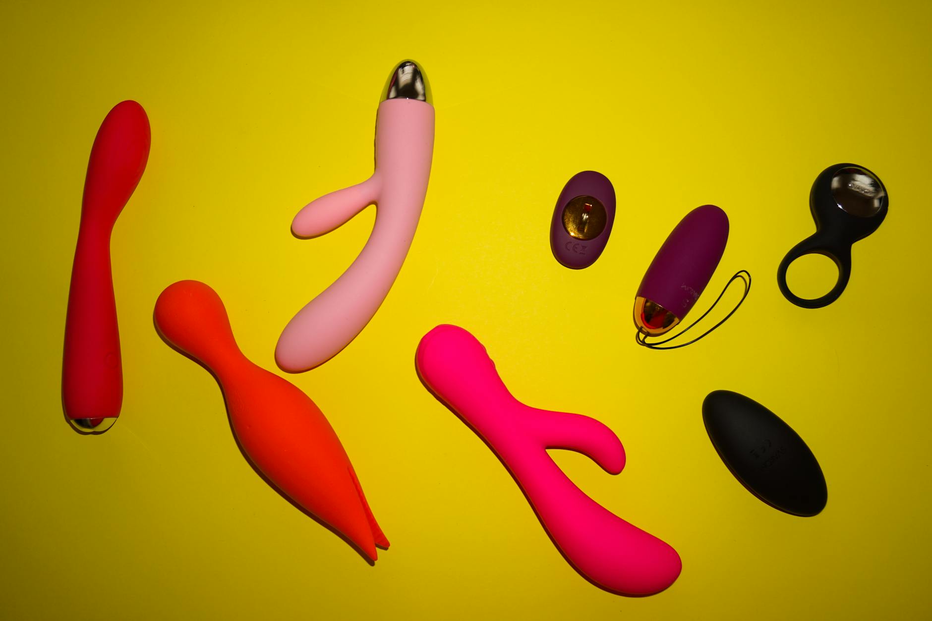 Close-up of hands holding a sleek blue vibrator against a purple background